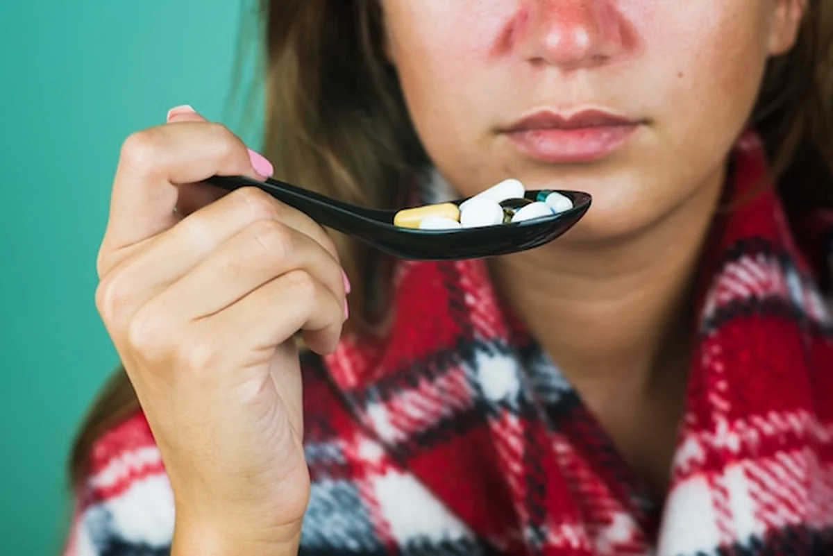 Chora kobieta je pigułki z łyżeczką