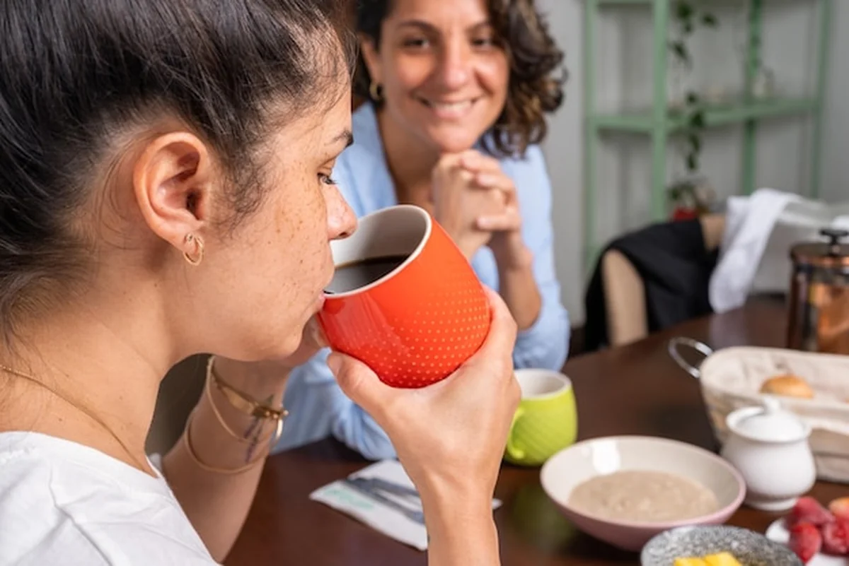 Kobieta pijąca kawę przy stole ze swoją parą