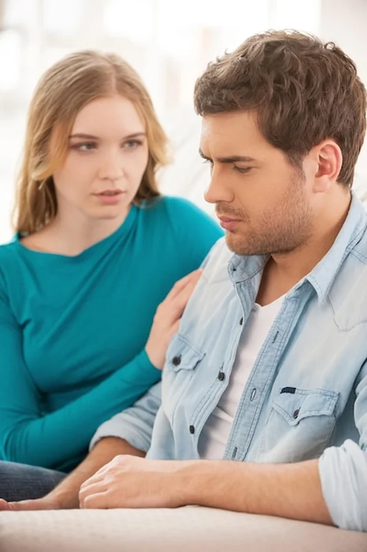 Młody mężczyzna i kobieta na kanapie w trudnej sytuacji w związku