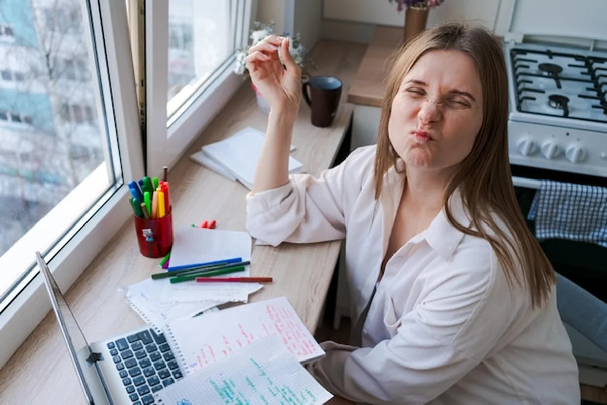 Kobieta siedzi przy biurku z laptopem i papierami