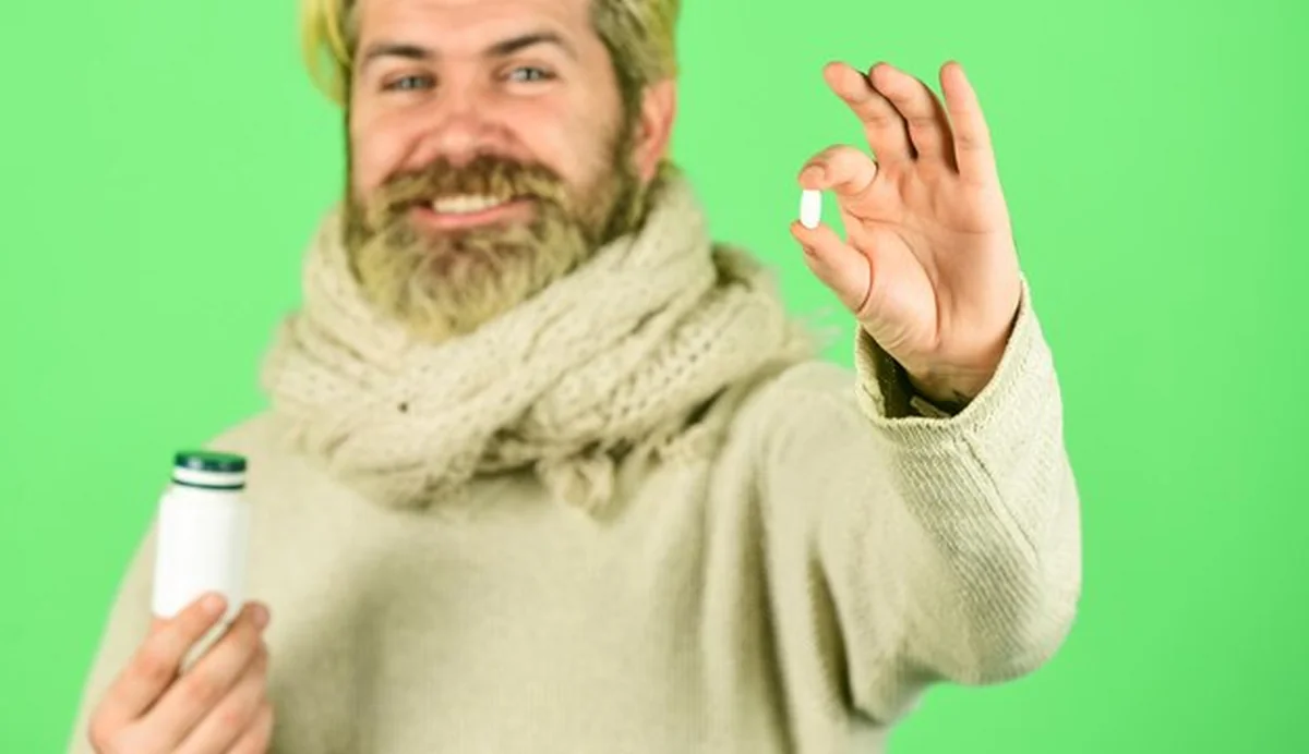 Dojrzały mężczyzna biorący tabletki przeciwbólowe