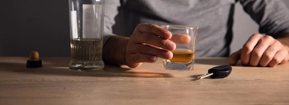 Mężczyzna trzymający szklankę alkoholu