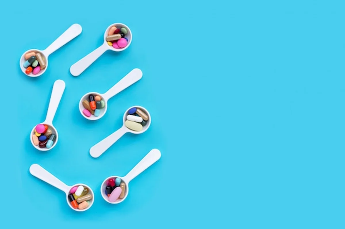 Kolorowe pigułki, tabletki i kapsułki na niebieskim tle