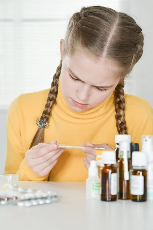 Chora dziewczyna mierzy temperaturę