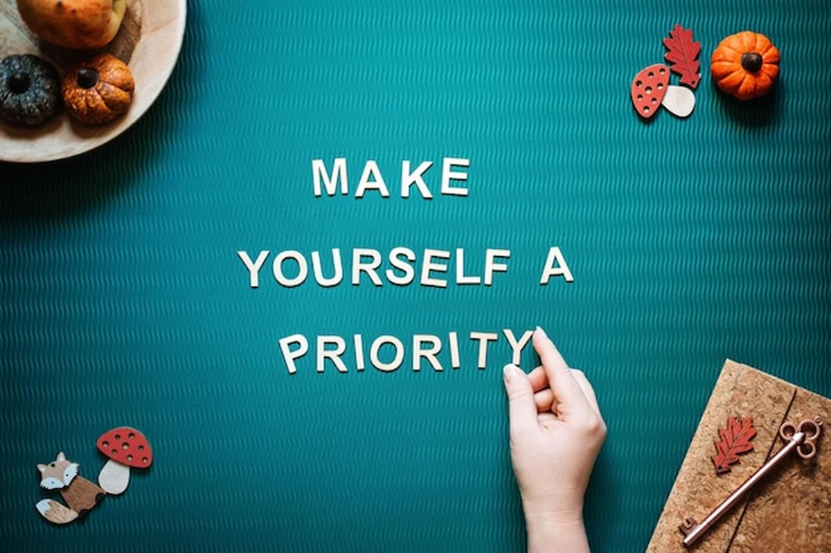 Kobiece dłonie na zielonym tle z cytatem o samoopiece