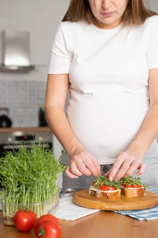 Młoda kobieta przygotowuje zdrowe kanapki z warzywami i mikrogrownami