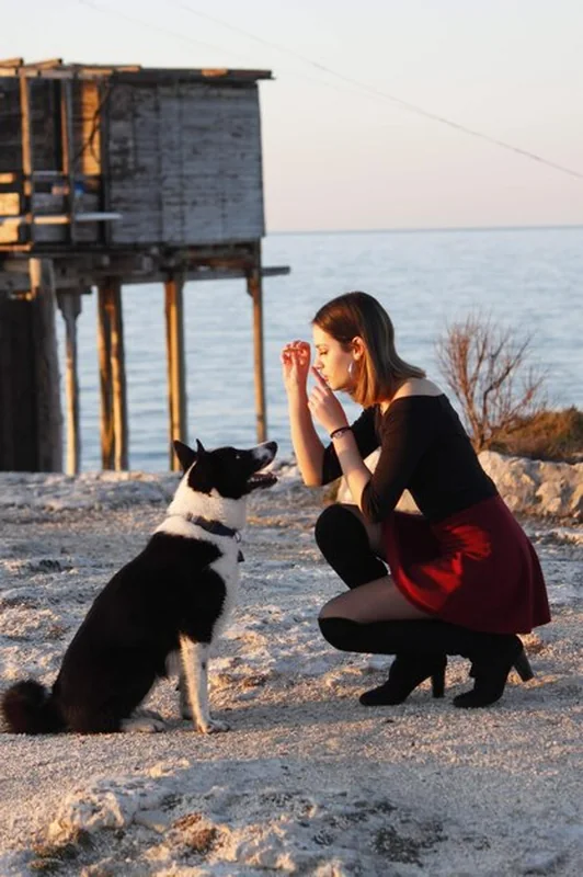 Młoda kobieta bawiąca się z psem na zewnątrz