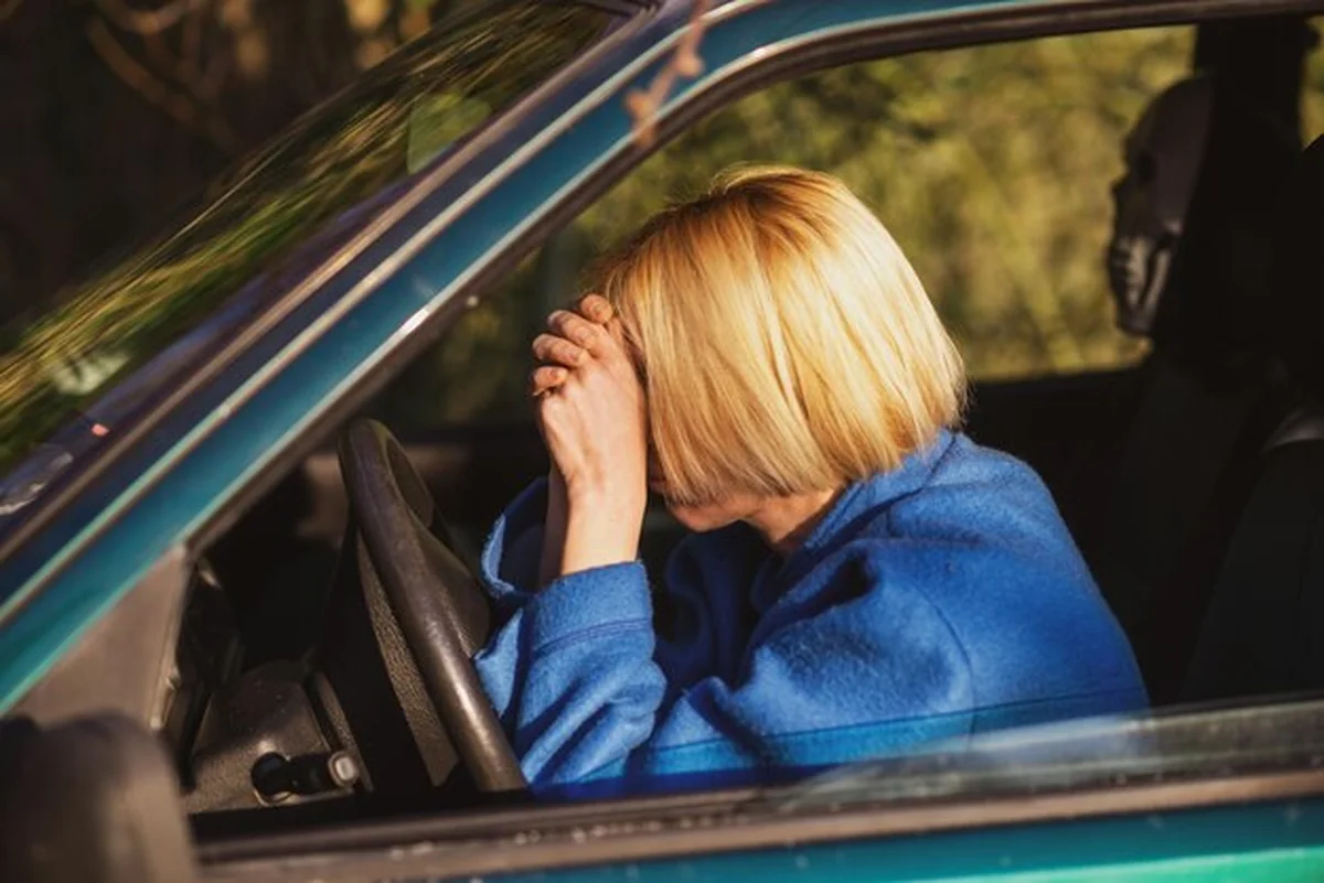 Zmęczona kobieta prowadząca samochód w średnim wieku