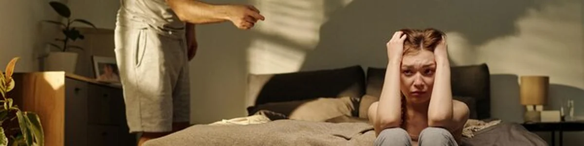 Kobieta siedząca na łóżku w trakcie konfliktu rodzinengo w domu