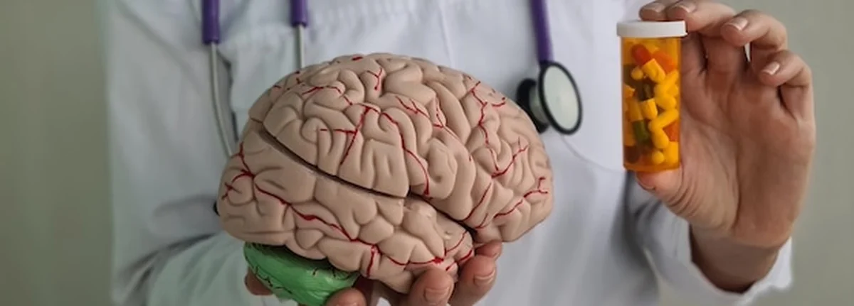 Lekarz neurolog trzyma pigułki przy modelu mózgu ludzkiego