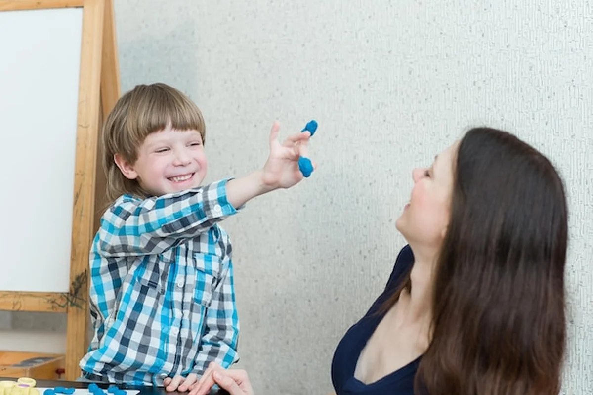 Dziecko, chłopiec i matka bawią się w kolorową glinę