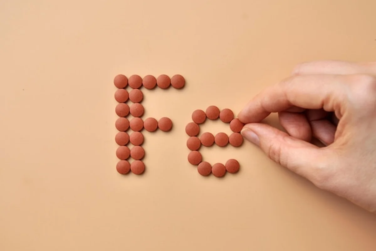 Tabletki z żelazem na tle minerału żelaza