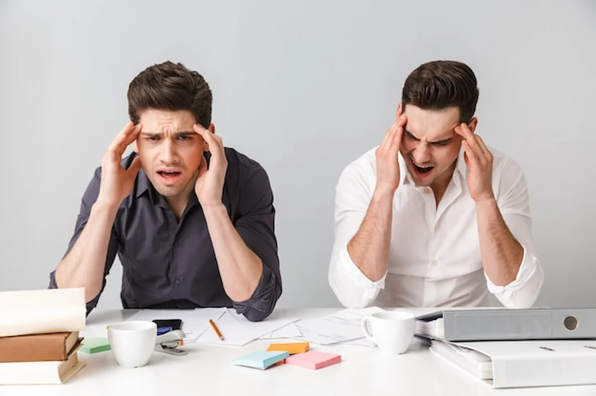 Dwóch młodych biznesmenów z bólem głowy