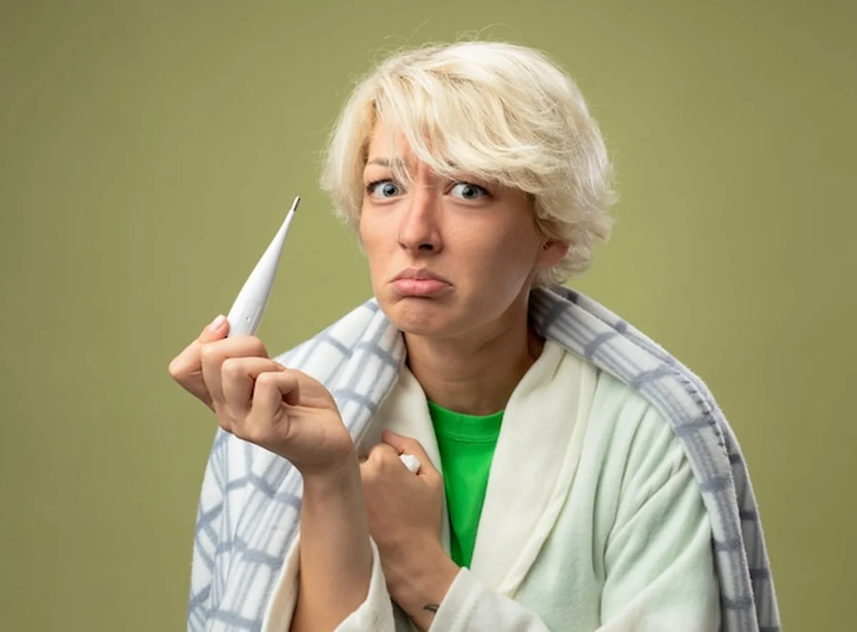 Chora kobieta z termometrem czująca się źle