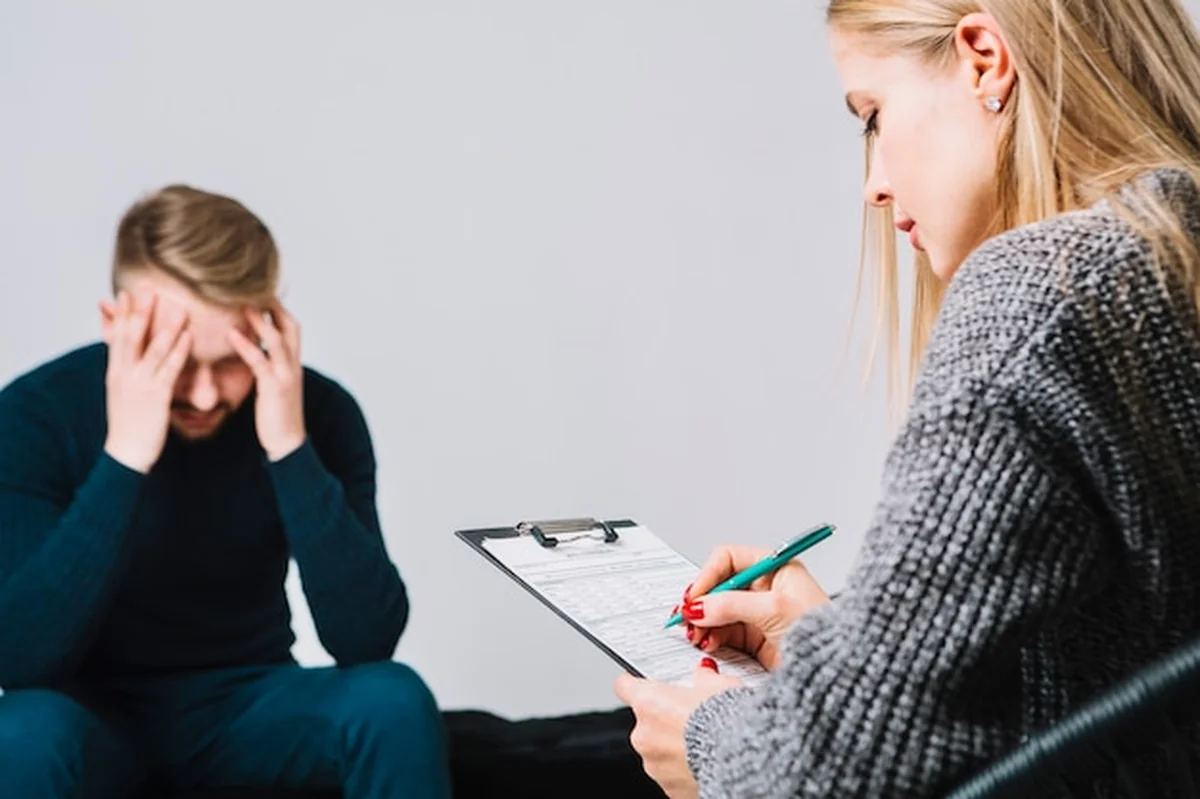 Psycholog prowadzi sesję z męskim pacjentem w biurze