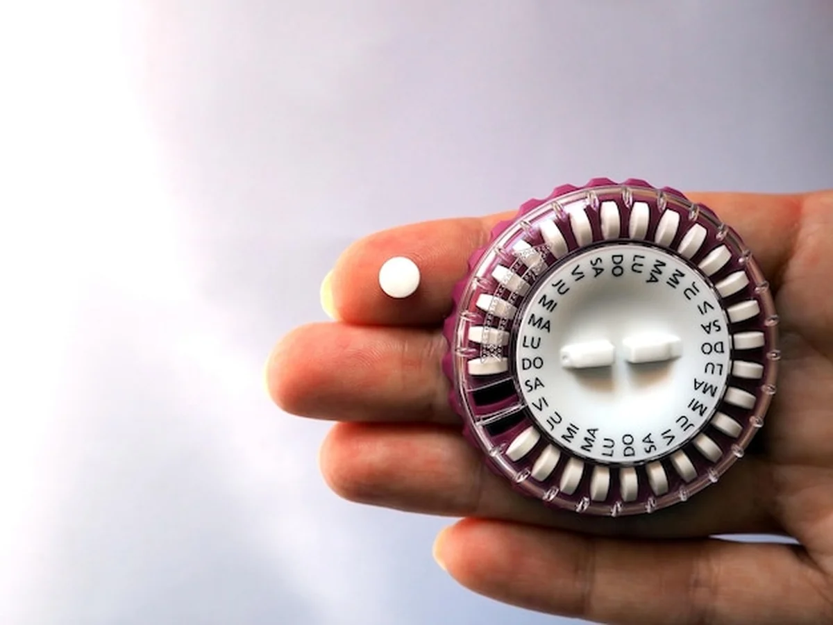Hormonalne tabletki antykoncepcyjne na kobiecej dłoni