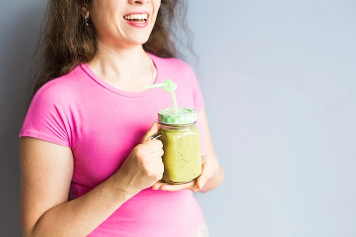 Zielony koktajl ze szparagami w dłoni kobiety