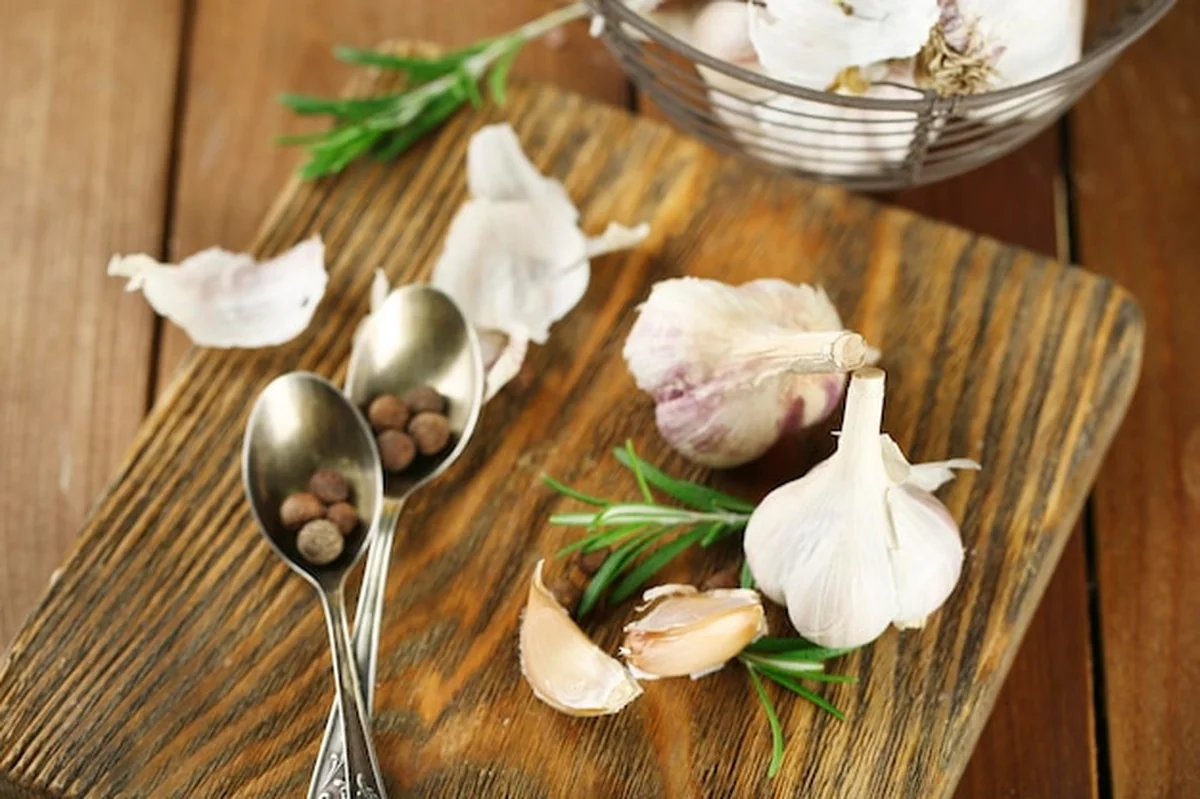 Surowy czosnek i przyprawy na drewnianym stole