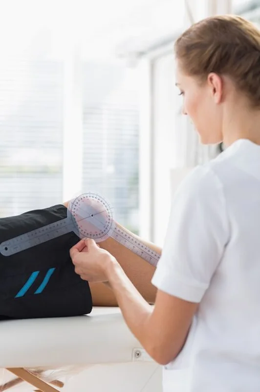 Fizjoterapeuta bada kąt kolana człowieka