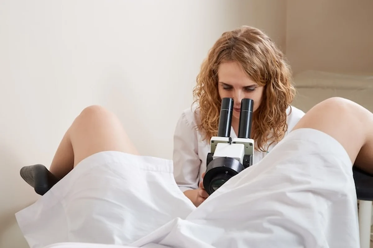Ginekolog badający pacjenta pod mikroskopem