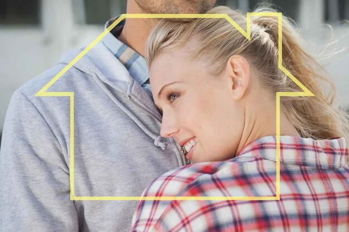 Modna młoda para przytulająca się przed zarysem domu