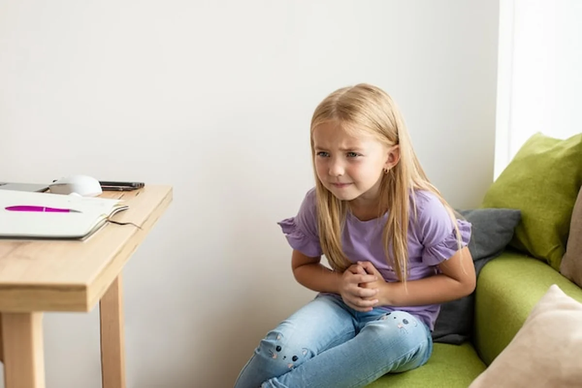 Dziecko trzyma brzuch, boli, zdrowie dzieci